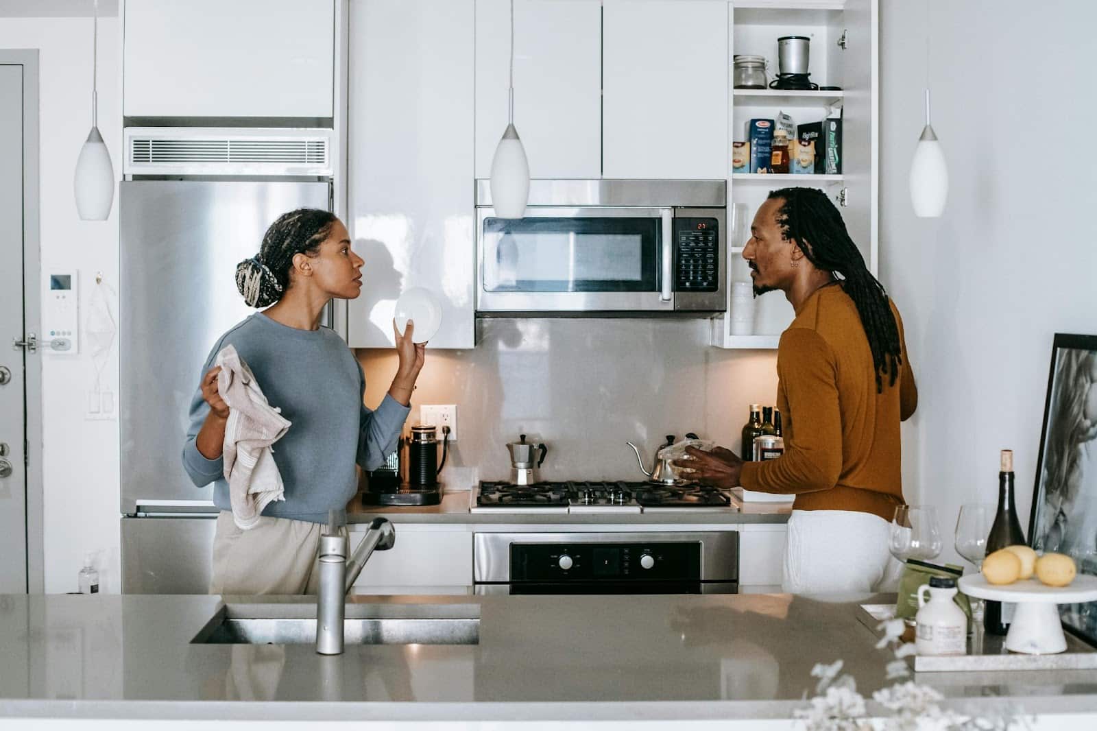 A man and woman at the kitchen having misunderstandings.