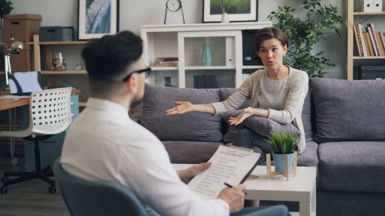 Man staying quiet while partner argues in living room.