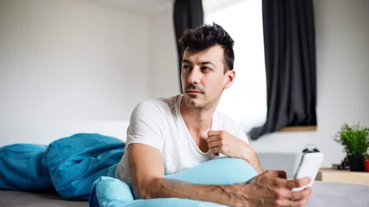 Man scrolling through social media with envious look.