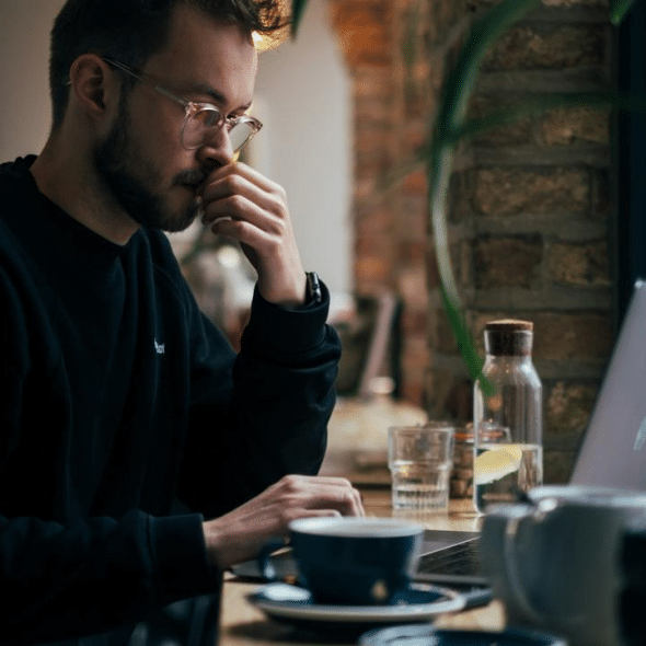 A man working on a laptop in a café.