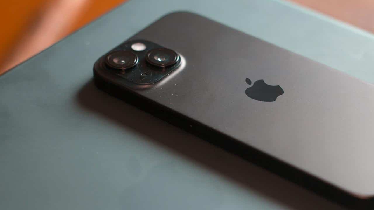 A black iPhone with dual cameras placed on a flat surface.