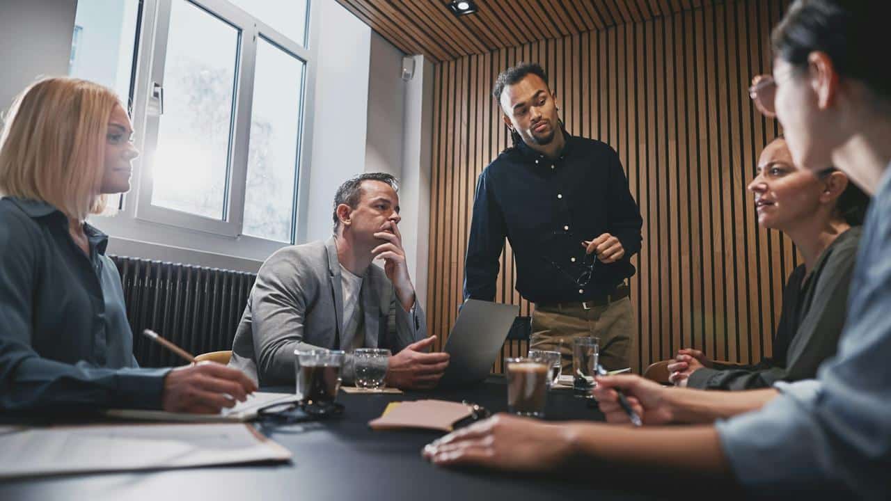 A group of colleagues having a discussion around a conference table.