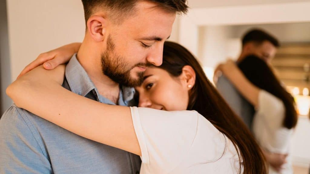 A couple embracing closely indoors with warm expressions.