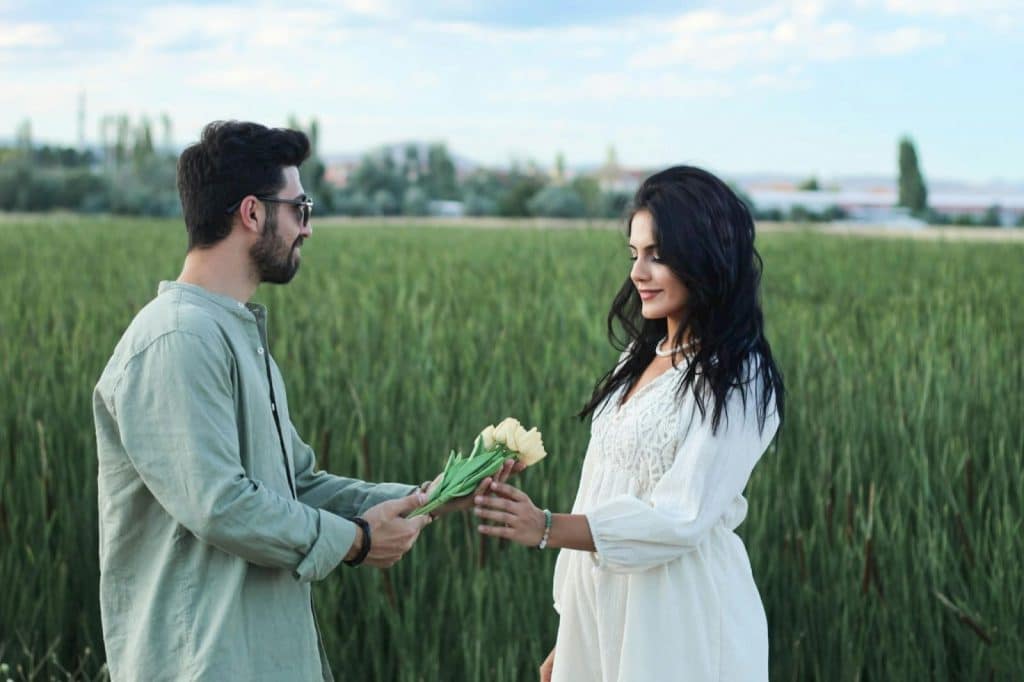 A man giving a flower to a woman