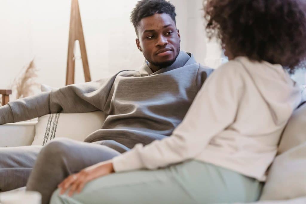 A man and woman sitting at the couch