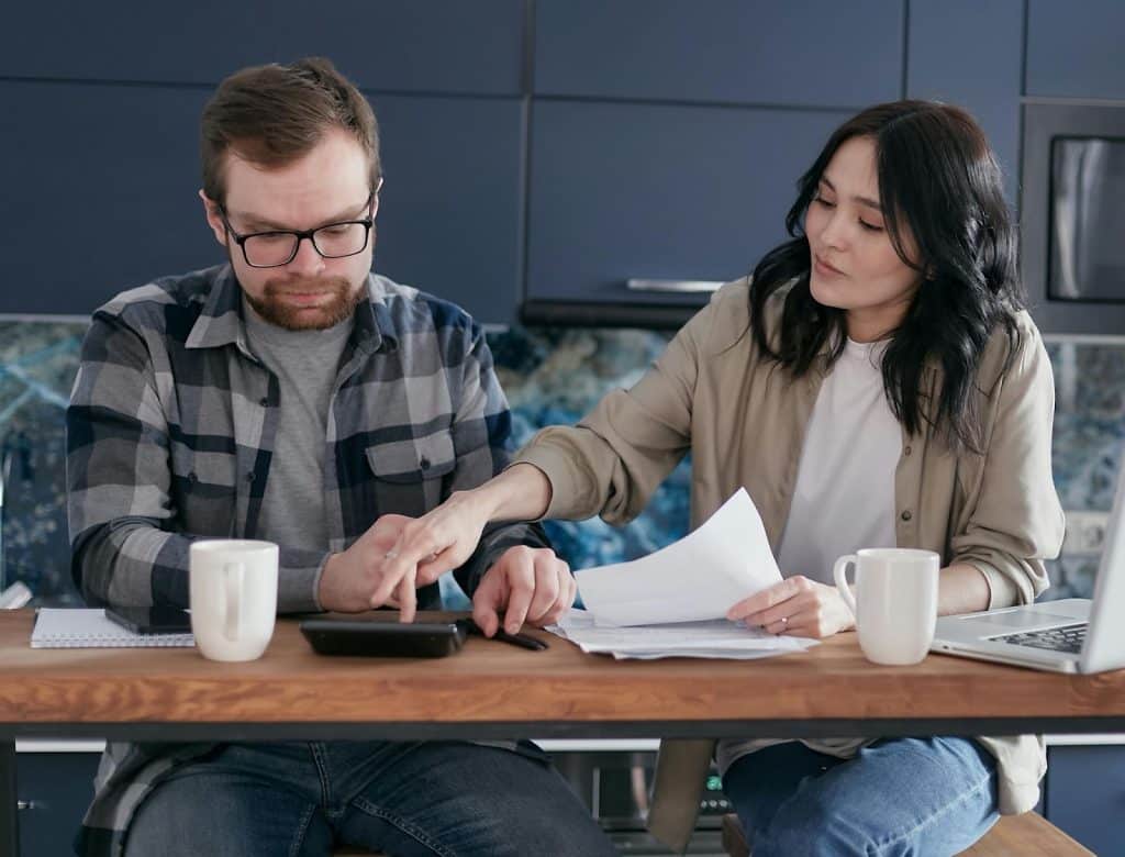 A man and woman computing their bills