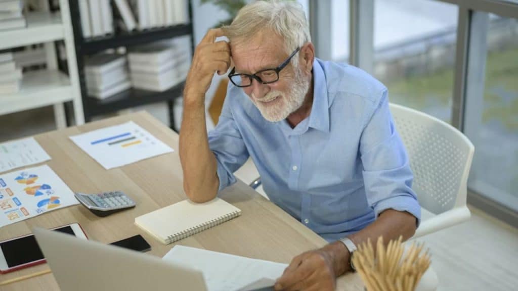 Older man at a desk with retirement paperwork