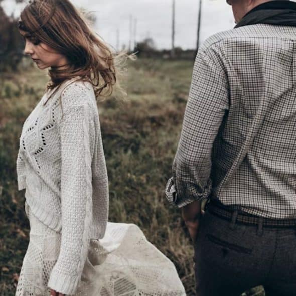 A woman walking away from a man on a quiet street, symbolizing separation