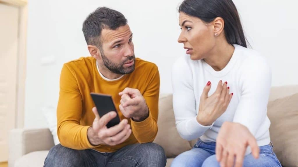 A couple arguing in their living room with tense expressions