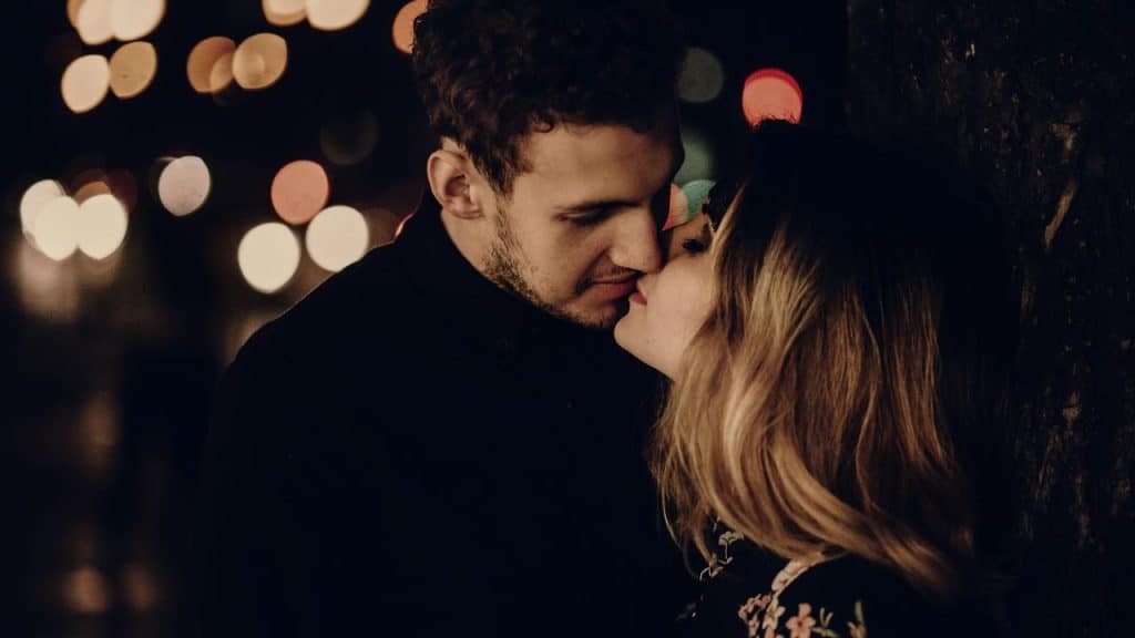 A couple about to kiss at night.