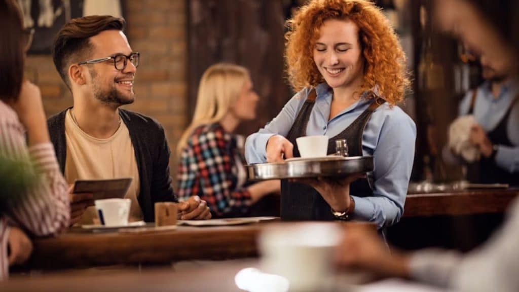 Man smiling while thanking a waitress