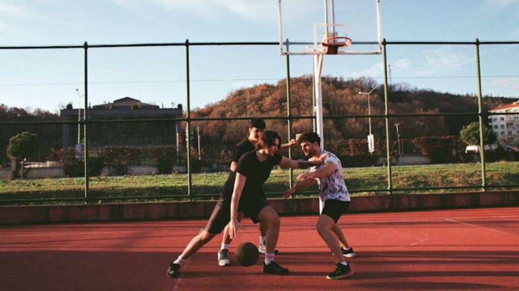 Man playing basketball with friends outdoors