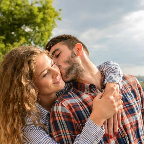 A man kissing a woman's cheek