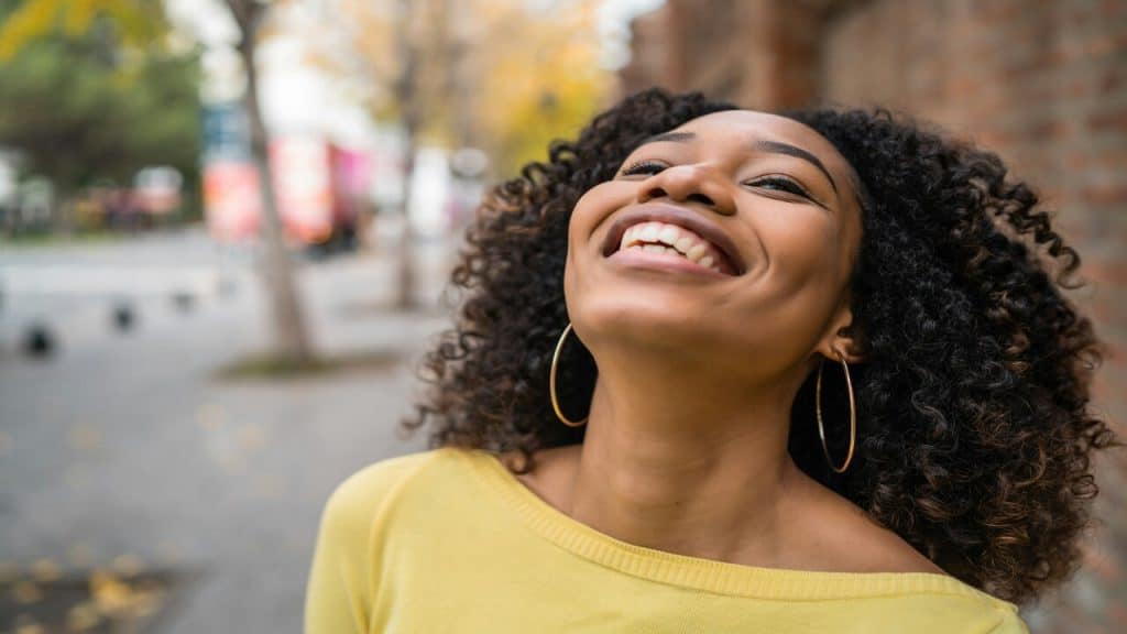 A woman laughing outdoors