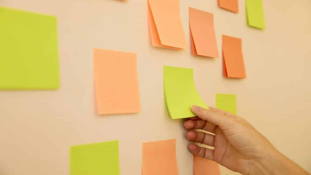 A hand picking up a post-it note