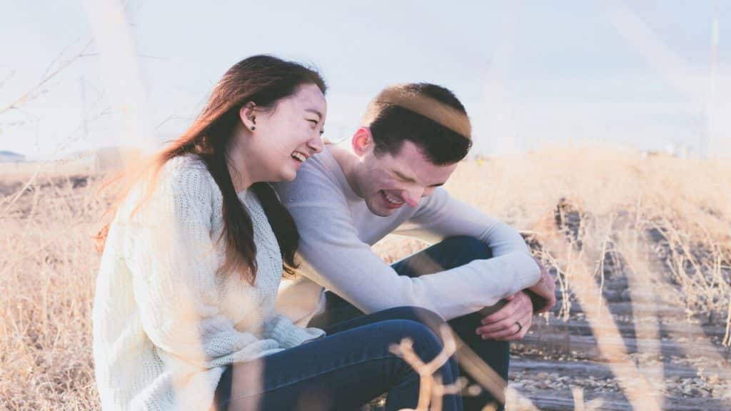 A couple laughing on a field