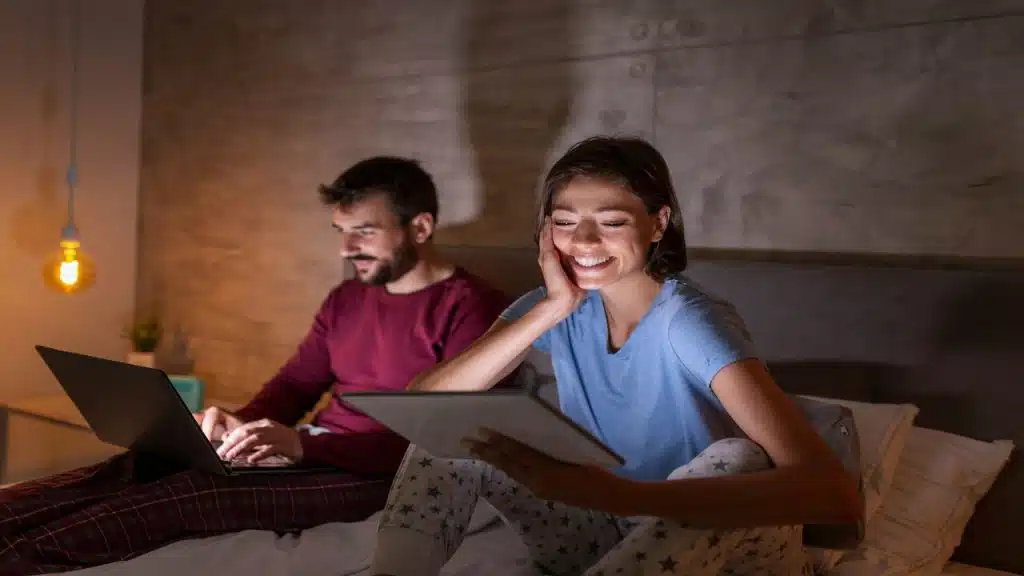 A couple using their devices at night