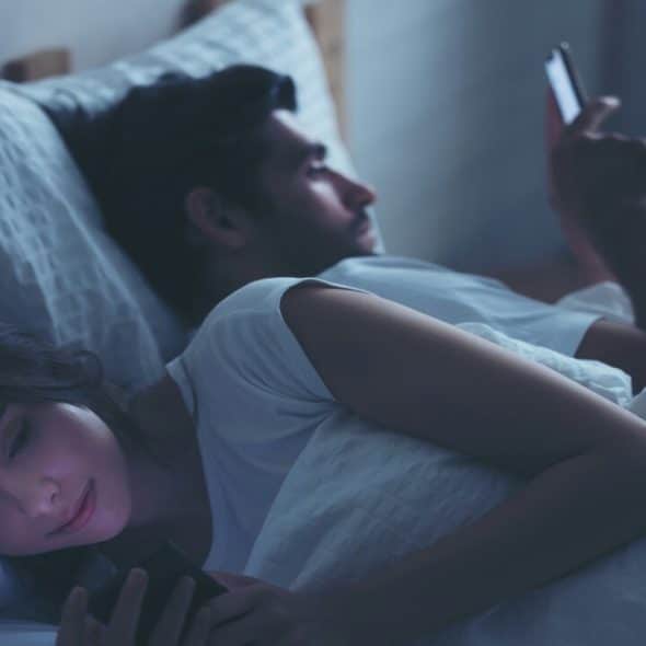 A couple using their phones late at night