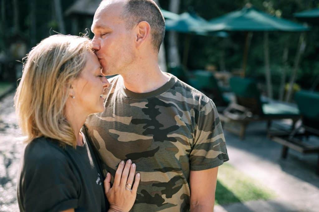 A man kissing a woman’s forehead