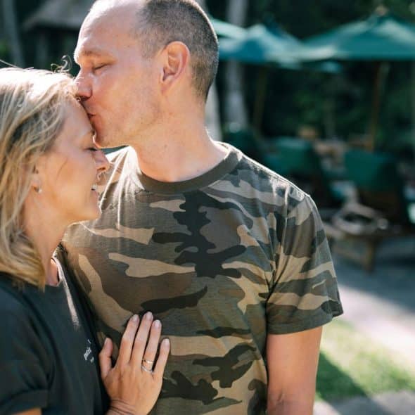 A man kissing a woman’s forehead