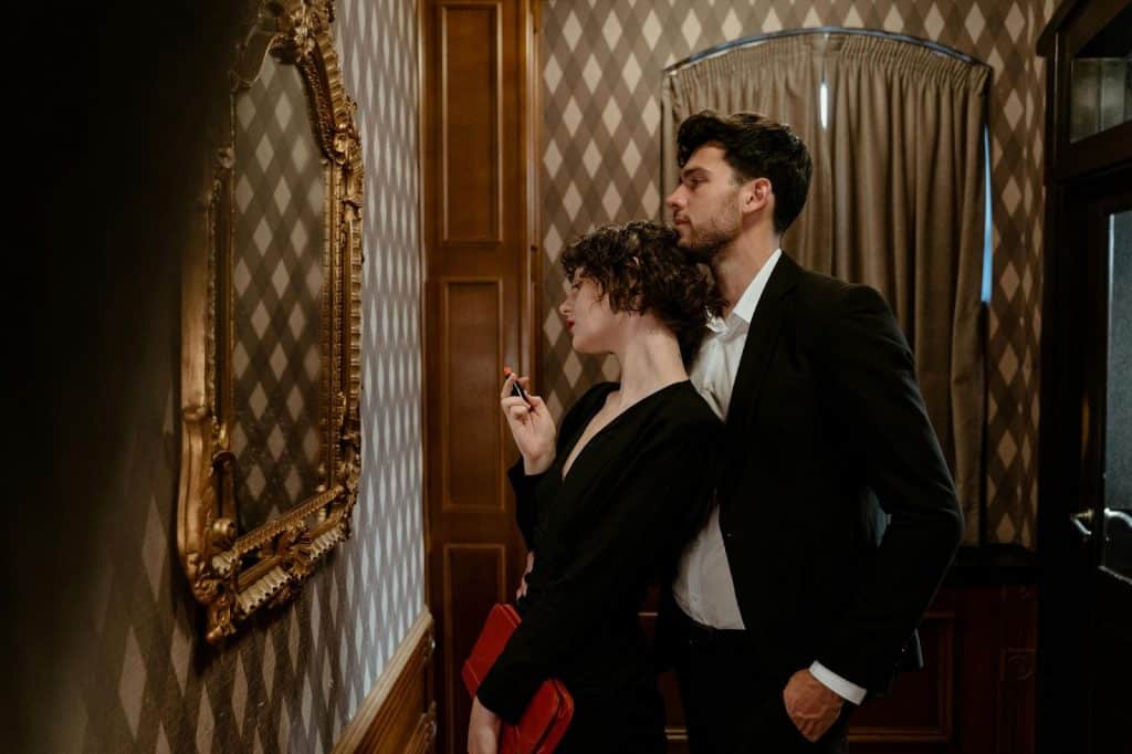 A man and woman looking at the mirror