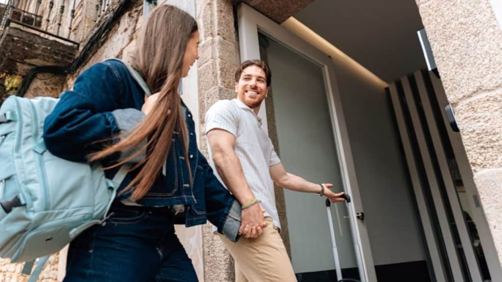 Man holding a café door open as woman walks through