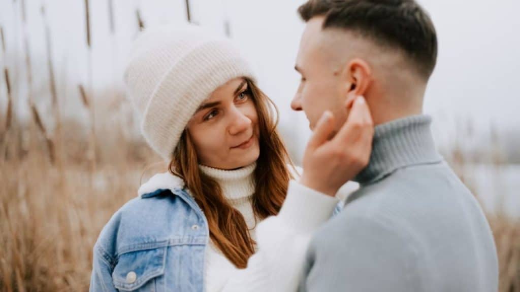 Man offering his jacket to a woman outdoors
