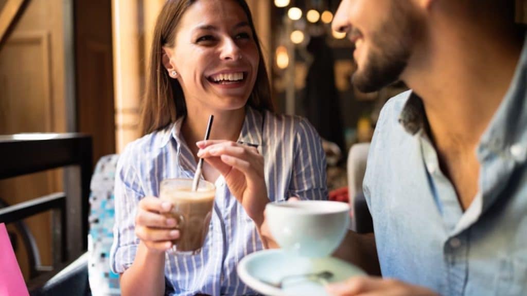 Man telling a funny story while woman laughs at table