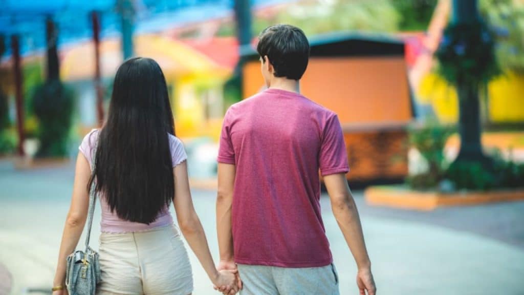 Man lightly touching woman’s arm while walking together
