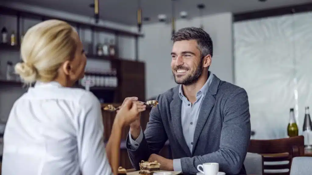 Woman subtly mirroring a man’s posture while chatting