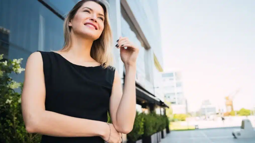 Woman smiling while flipping her hair upon looking at the man
