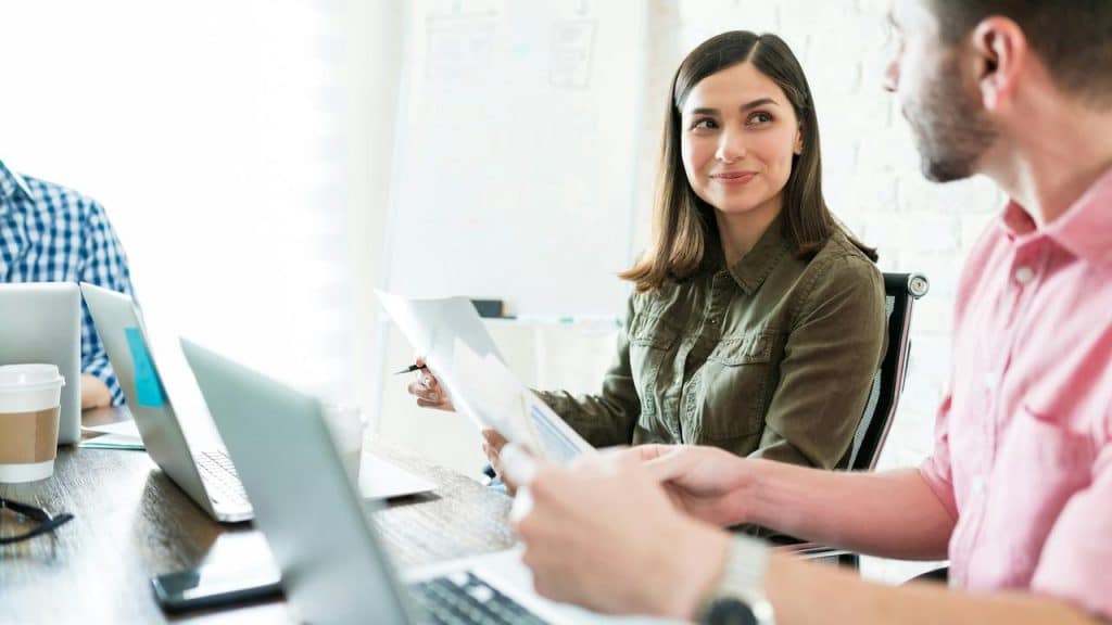 A woman smiling at a male colleague during a meeting