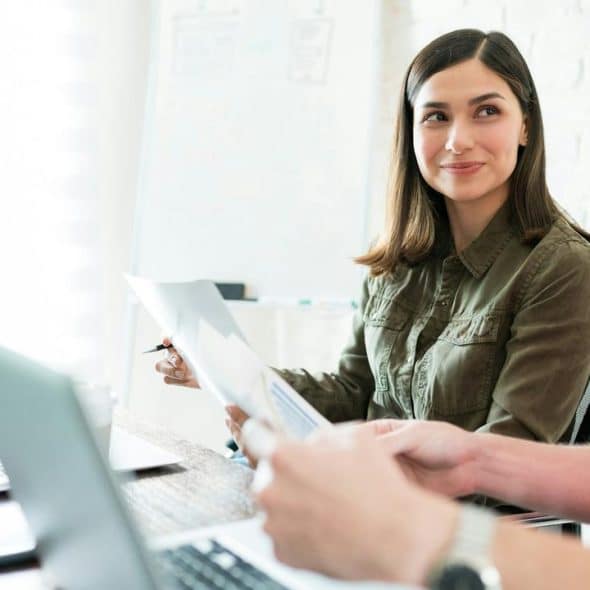 A woman smiling at a male colleague during a meeting