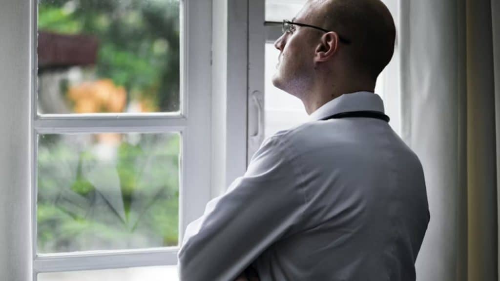 Man in an office cubicle looking out the window