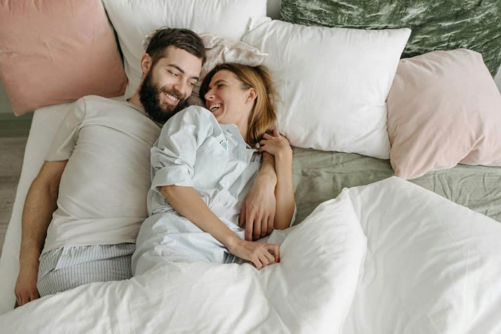 A man and woman laying on the bed