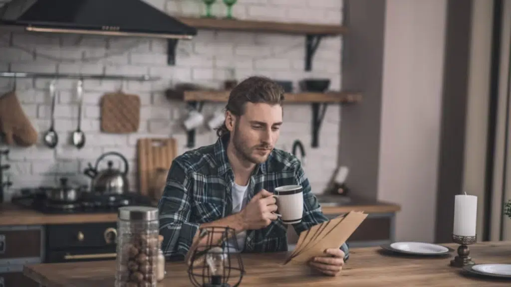 A thoughtful man sitting alone in the kitchen, reflecting