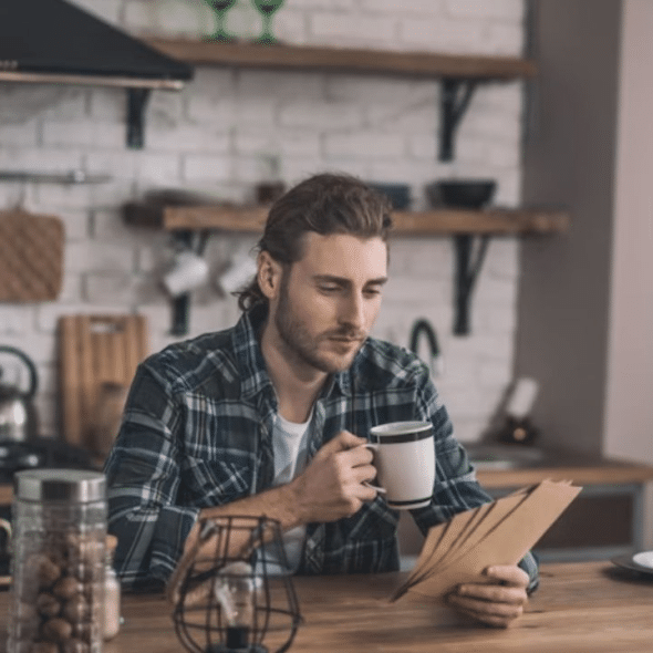 A thoughtful man sitting alone in the kitchen, reflecting