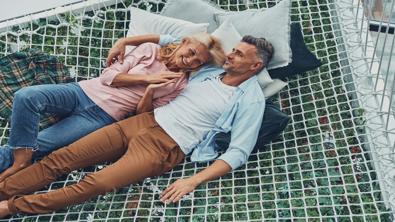 A mature couple on a hammock.
