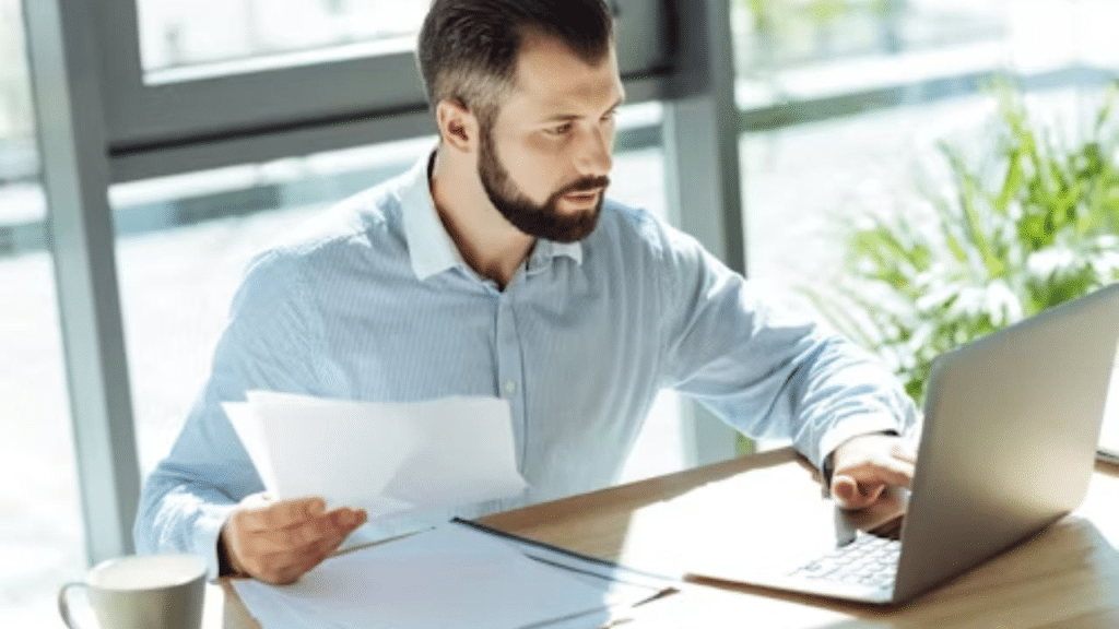 Man looking stressed while reviewing bills at home