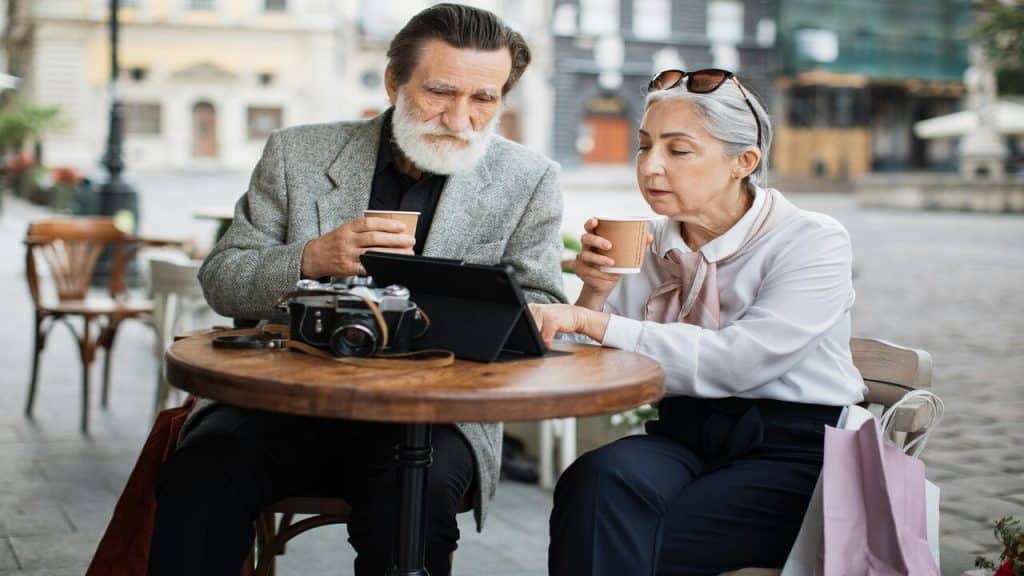 A stylish older couple looking at an iPad