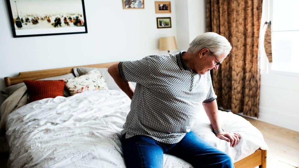 An older man clutching at his back