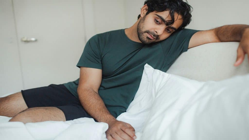 A man looking sad in the bedroom