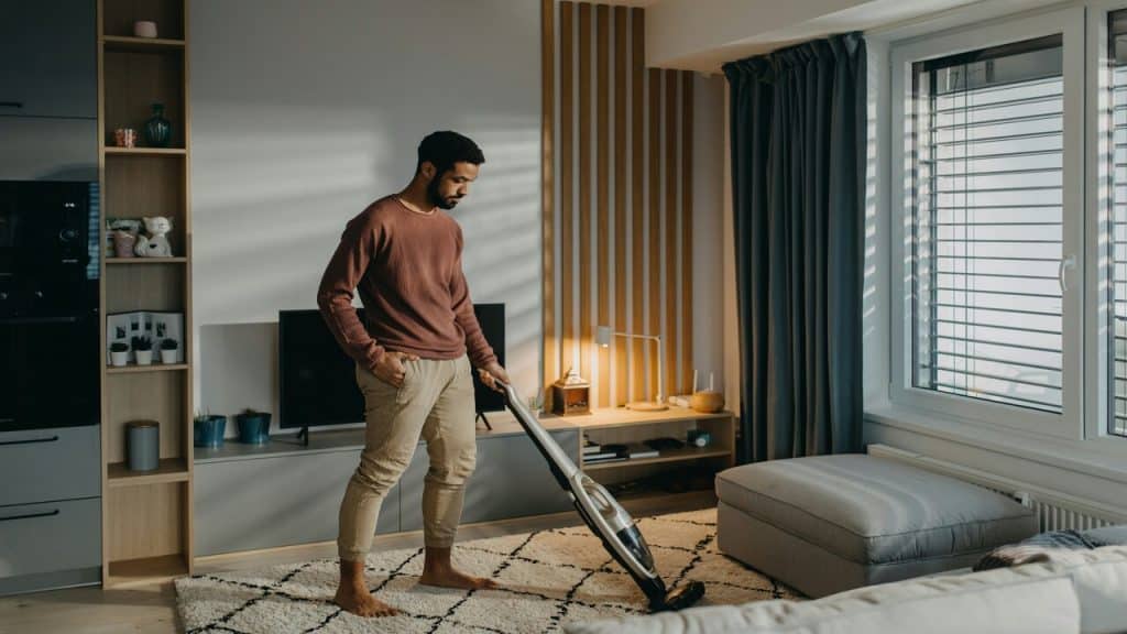 A man cleaning the living room