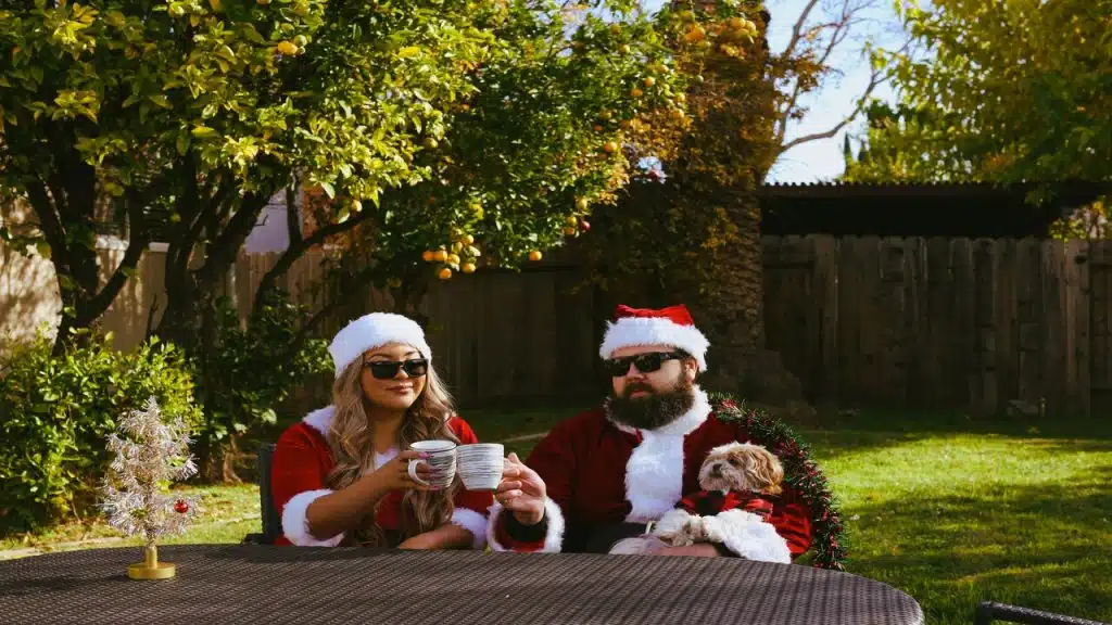 A couple with their dog in the yard at Christmas