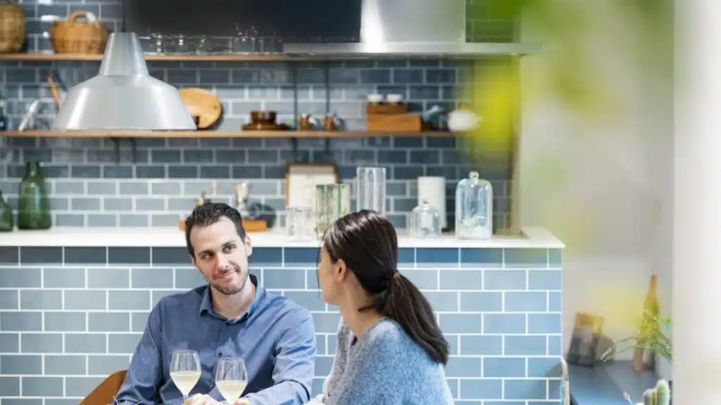 Husband and wife sitting at a kitchen table having a serious conversation