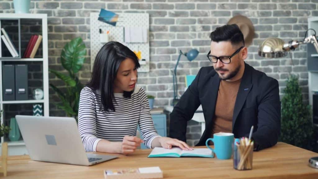 Couple reviewing finances together with a laptop and notepad