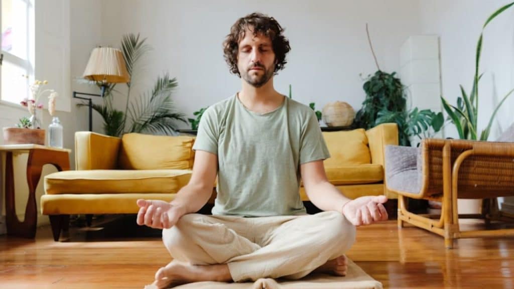 Man sitting calmly in meditation at home