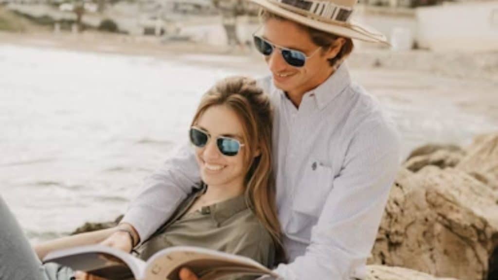 Man reading a new book while wife smiles