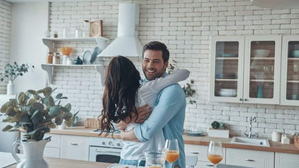 Husband hugging wife warmly in the kitchen