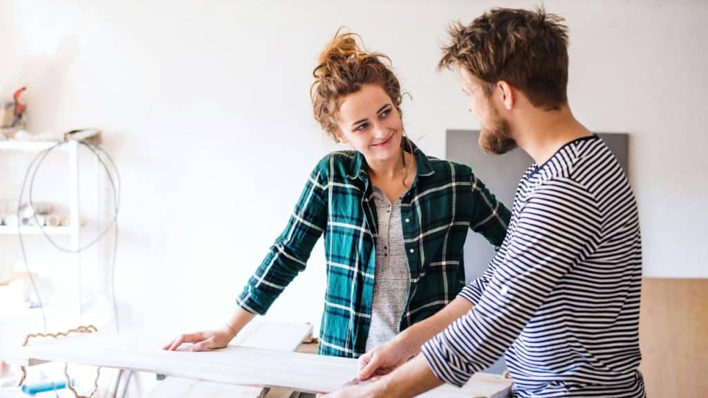 A couple working together on a home project and sharing a smile.